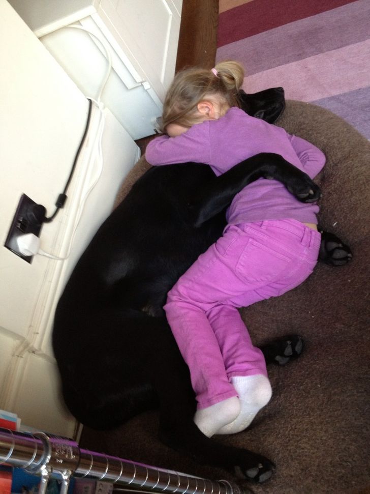 little girl cuddles with her dog